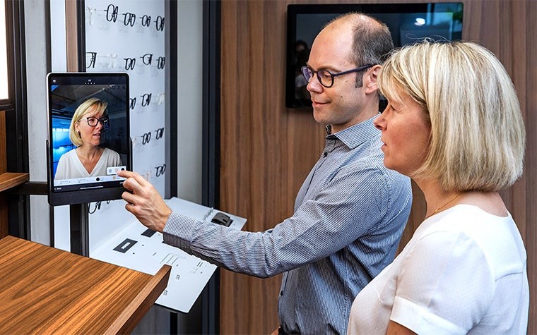 Professionnel de la lunetterie et patient utilisant le scanner à ajustement personnalisé et l'installation de lunetterie